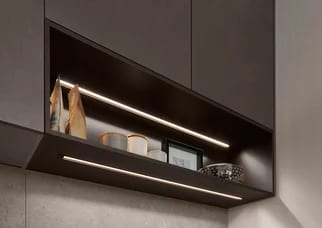 Luminaire LED encastré sous un meuble haut sombre, éclairage homogène sur la niche ouverte