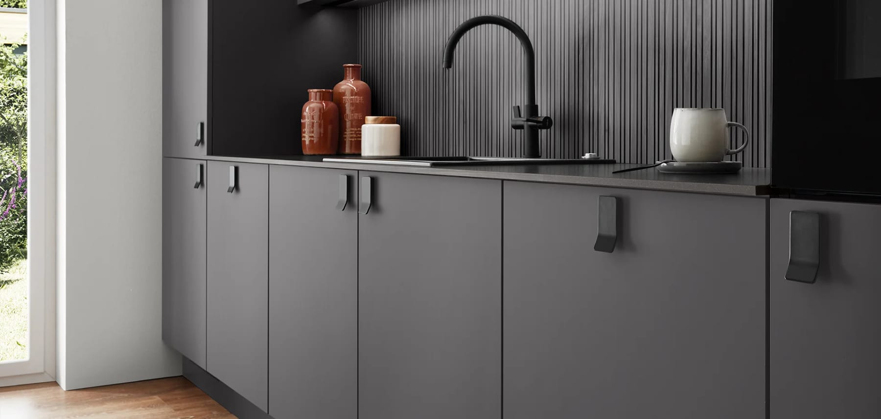 Façades de cuisine gris ardoise sans poignée, plan de travail sombre et crédence à lames verticales